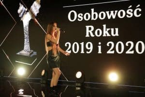 Plakat z napisem: “ Osobowość Roku 2019 i 2020”. Na scenie śpiewa młoda kobieta.