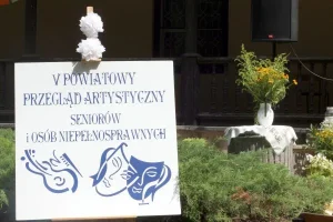 Plakat z opisem: „Piąty Powiatowy Przegląd Artystyczny Seniorów i Osób Niepełnosprawnych”. Pod nim rysunki przedstawiające skrzypce oraz dwie maski symbolizujące teatr.