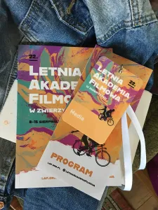 Broszurki i ulotki Letniej Akademii Filmowej na tle dżinsowej kurtki