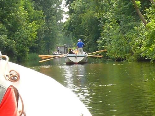 Na zdjęciu spokojny spływ rzeką mniejszymi łódkami z wiosłami.