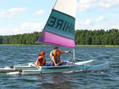 Na zdjęciu kobieta i mężczyzna na małej żaglówce.