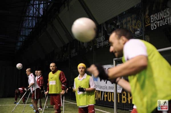 Na zdjęciu piłkarz przyjmuje piłkę głową.