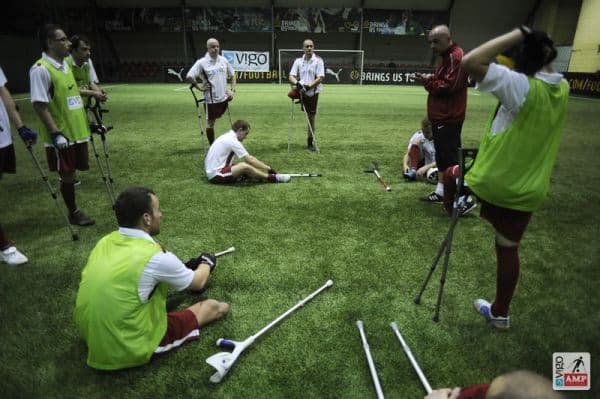 Rozciąganie się piłkarzy. Skłony w pozycji siedzącej.