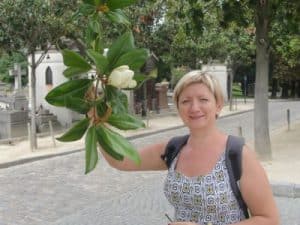 Na zdjęciu Anna prezentuje do zdjęcia jakąś egzotyczną roślinę z wielkimi liśćmi.