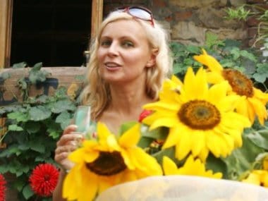 Portret zdjęciowy Sylwia Góźdź. Blond włosy długie. Schowana za wielkim bukietem słoneczników.