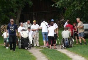 Grupa wycieczkowa - osoby starsze, o kulach na wózkach innwalidzkich