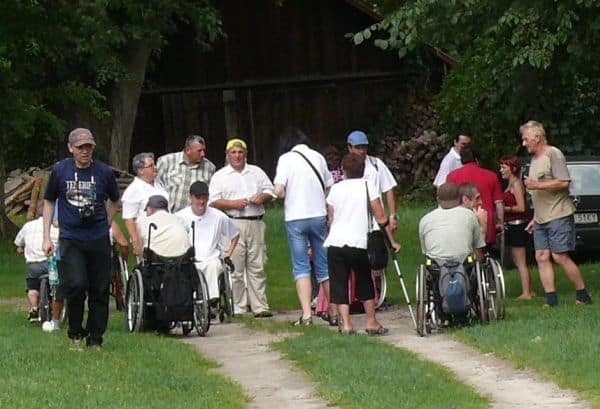 Grupa wycieczkowa - osoby starsze, o kulach na wózkach innwalidzkich