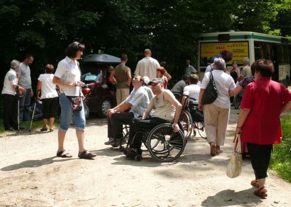 Grupa wycieczkowa pod autobusem niskowejściowym.