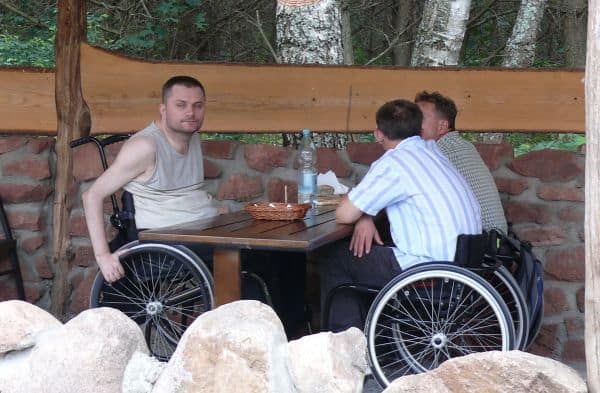 Wózkowicze w karczmie przy stole.