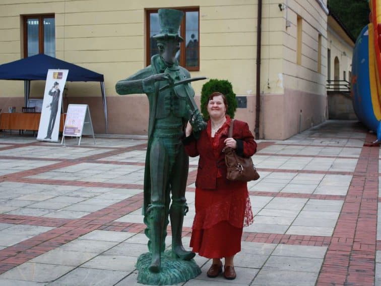 Dorota Szpak pozuje obok pomnika grającego na skrzypka pasikonika w Szczebrzeszynie