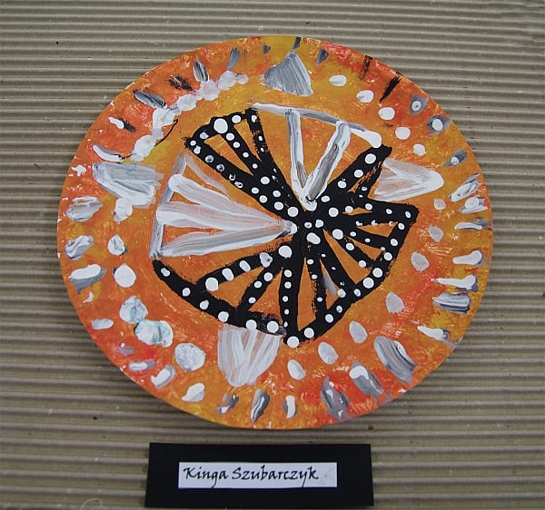 Talerz z “Tanganiki”. Rękodzieło z użyciem papierowego talerza pomalowanego w kolorowe wzory pomarańczowo żółto czarne.