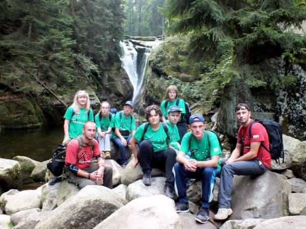 34 Drużyna Harcerska Nieprzetartego Szlaku „Warsztaciaki” pozuje na tle wodospadu podczas wycieczki.