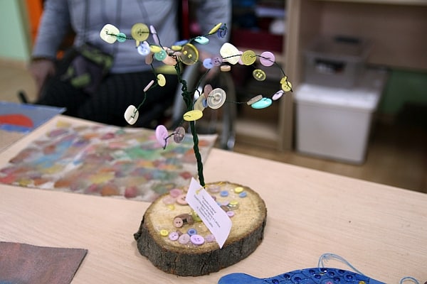 Drzewko szczęścia Dominiki. Podstawkę stanowi drewniany krążek, drzewko jest druciane. Jako liście na gałęziach stanowią różne guziki.