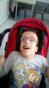 Dwunastoletnia Hania Bednarz w okularach w specjalnym wózku spacerowym dziecięcym