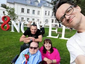 Paweł Iwaniuk z grupą ludzi w plenerze. Fotografia w stylu selfie wykonana przez jednego z facetów na zdjęciu.