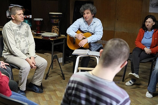 Ludzie siędzący w kręgu, ćwiczenia grupy do spektaklu.