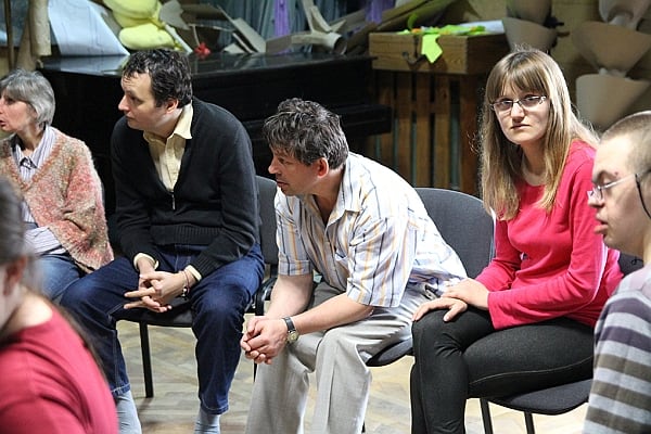 Ludzie siędzący w kręgu, ćwiczenia grupy do spektaklu.