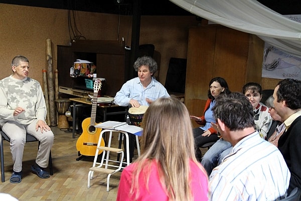 Ludzie siędzący w kręgu, ćwiczenia grupy do spektaklu.