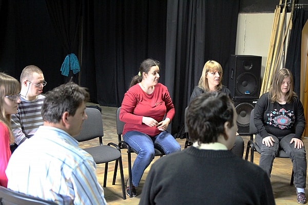 Ludzie siędzący w kręgu, ćwiczenia grupy do spektaklu.