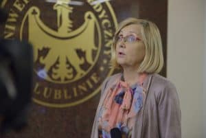 Kobieta ma twarz skierowana na wprost. Usta ma lekko otwarte.