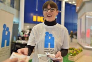 Kobieta w okularach trzyma w dłoniach ulotki.