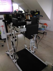 Sprzęt do rehabilitacji w dużym pokoju. Przed nim ekran.