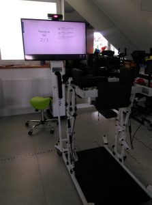 Sprzęt rehabilitacyjny wraz z ekranem wyświetlającym dane.