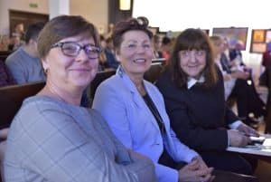 Kobiety siedzą na widowni. Twarze są zwrócone przed siebie.