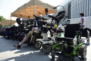 Wózki inwalidzkie stoją w rzędzie ma deptaku w miescie.