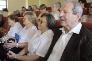 Trzy kobiety i mężczyzna siedzą na fotelach. Wszyscy patrzą przed siebie.