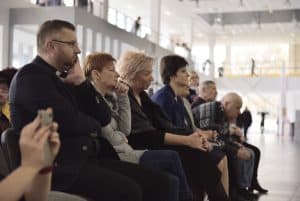 Ludzie siedzą na widowni. patrzą przed siebie.