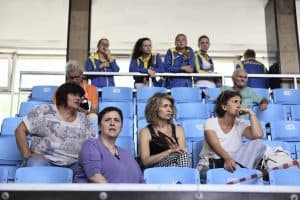 Ludzie siedzą na widowni. Ich twarze są skeirowane na wprost.