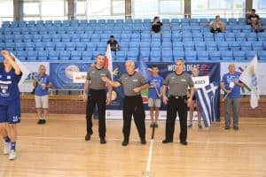 Mężczyzn stoją na środku boiska. Mają ręce założone na siebie.