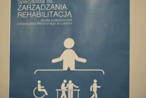 Plakat na którym jest grafika człowieka rozpościerający dłońmi pod nimi jest grafika człowieka na wózku inwalidzkim, ludzi trzymających się za barierkę oraz osoby idącej.