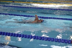 Mężczyzna płynie kraulem na swoim torze.