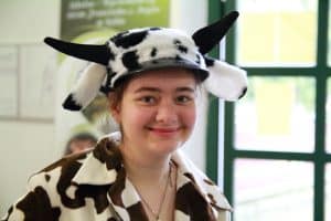 Do obiektywu uśmiecha się dziewczyna. Jest przebrana za krowę.