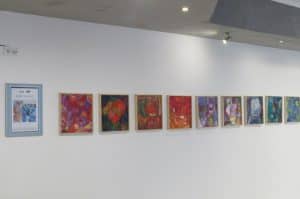 Na ścianie są ściany kolorowe obrazy. Ściana jest biała i czysta.