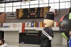 Tablica z wynikami meczów. Po prawej stronie stoi wielka postać górnika - maskotki.