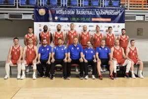 Reprezentacja w czerwonych i niebieskich ubraniach pozuje do zdjęcia.