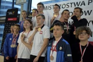 Grupa chłopców stoi razem i pozuje do zdjęcia. Mają na sobie medale.