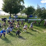 Grupa uczestników wykonuje rozgrzewkę przed startem.