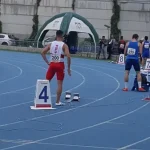 Zawodnicy przygotowują się do biegu na torze.