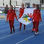 Zawodnicy trzymają flagę Mistrzostwa Świata w Lekkoatletyce Niesłyszących w czasie otwarcia olimpiady.