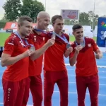 Zawodnicy z Polski pokazują swoje medale pozując do fotografii.