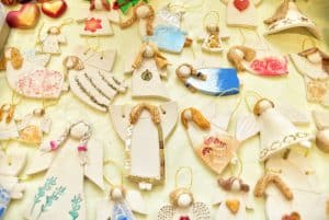 Rękodzieła ręcznie robionych aniołków. W oddali za aniołkami dwie figurki serca.