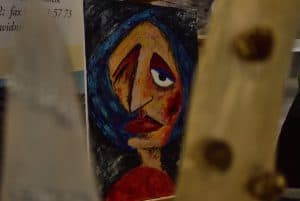 Ręczne malowidło twarzy kobiety. Wyraz twarzy jest smutny.