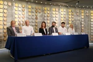 Uczestnicy konferencji siedzą przy stole prezydialnym