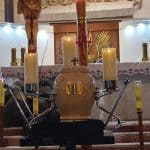 Zbliżenie na urnę ustawioną na katafalku i pod nią tabliczkę nagrobną: Ś. P. Adam ORZEŁ żył lat 69 zmarł 25 marca 2022 roku. Jezu Ufam Tobie.