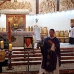 Ksiądz przy urnie dokonujący okadzania kadzidłem. W tle ołtarza stoi ministrant w wieku średnim.