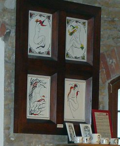 Obraz wiszący na ścianie. Jest na m=cztery malunki nagich kobiet.